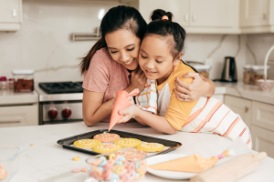 mom and daughter baking cookies. 